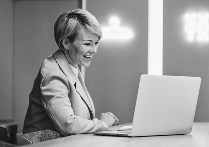 Woman laughing at a laptop for some reason